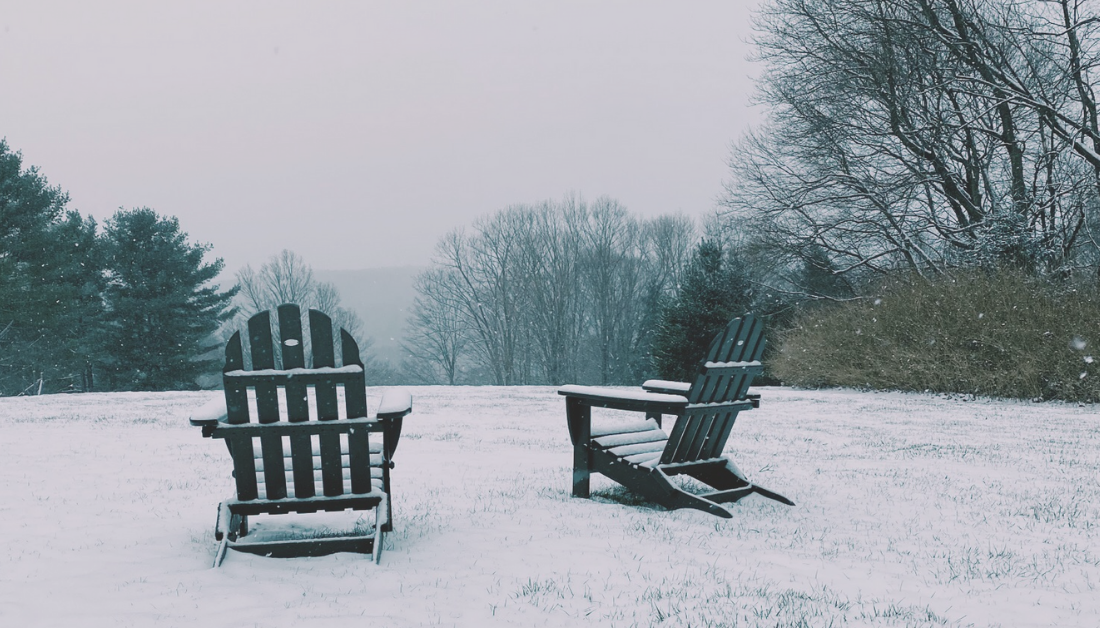 snowy hill with two empty lawn chairs