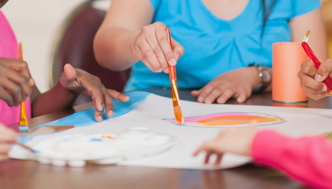 picture of the hands of students painting with with their Sunday school teacher