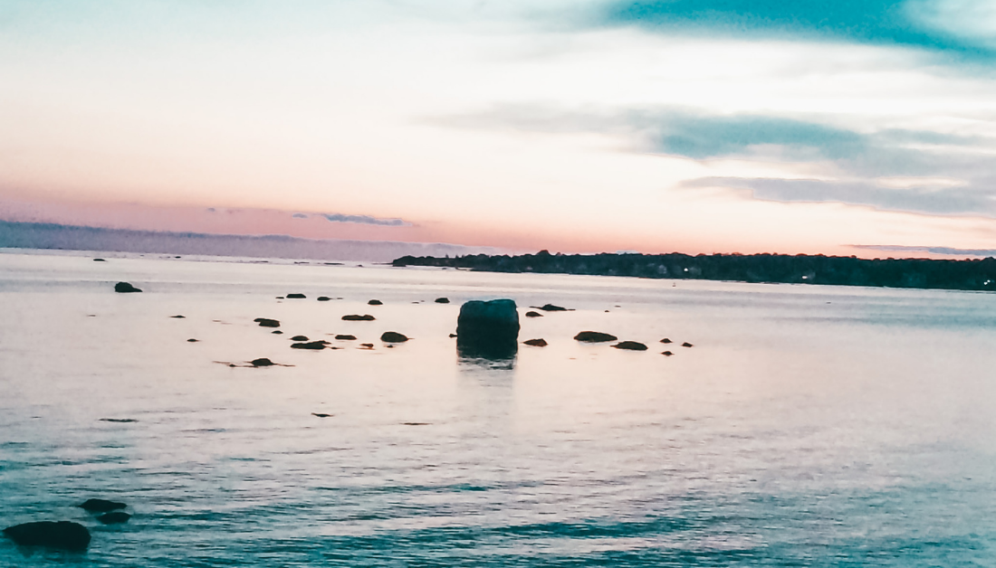 picture a peaceful lake with a rock sticking up in the middle of the water