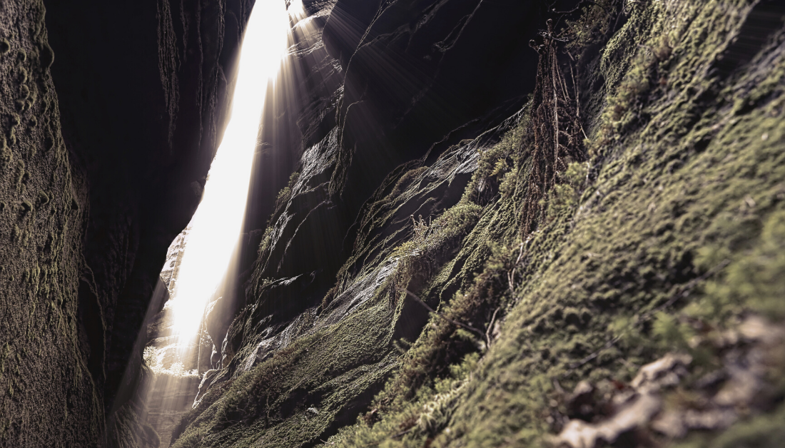 picture of light shining through a cleft in the rocks