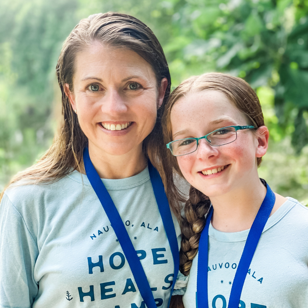an outdoor picture of Amy Julia and Marilee wearing matching blue Hope Heals t-shirts and smiling at the camera