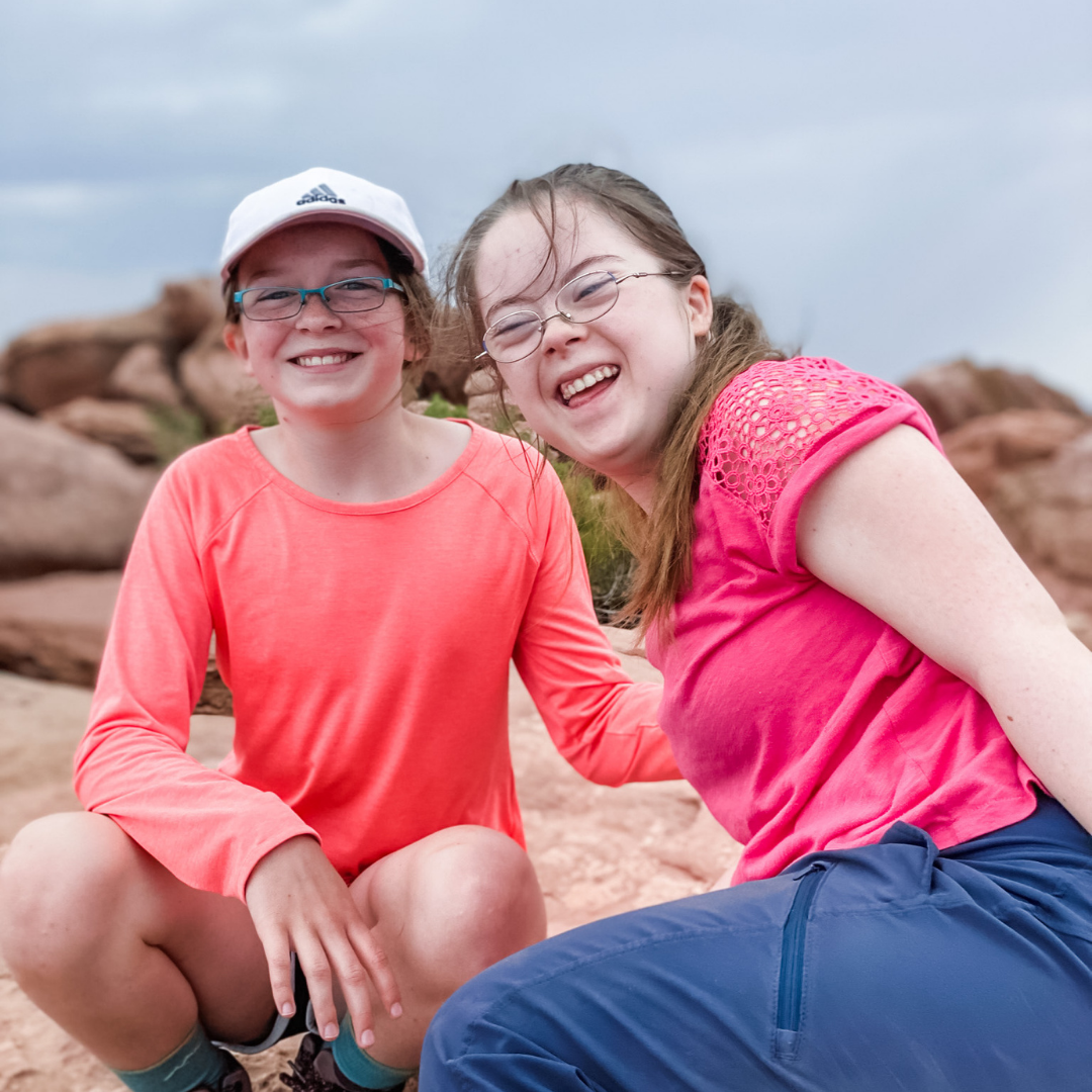 Marilee and Penny smiling and sitting on rock formation