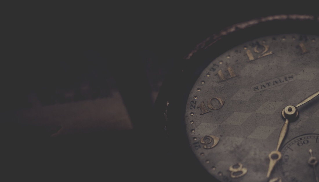 an analog clock with a dark background behind it.