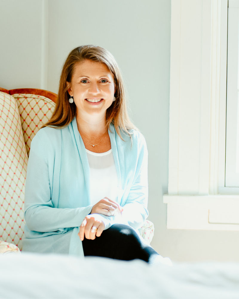 Amy Julia sitting in chair next to a window