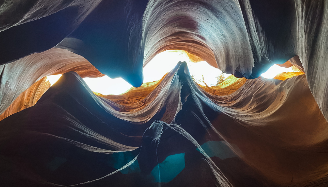 looking up at the sky through curving rock formations