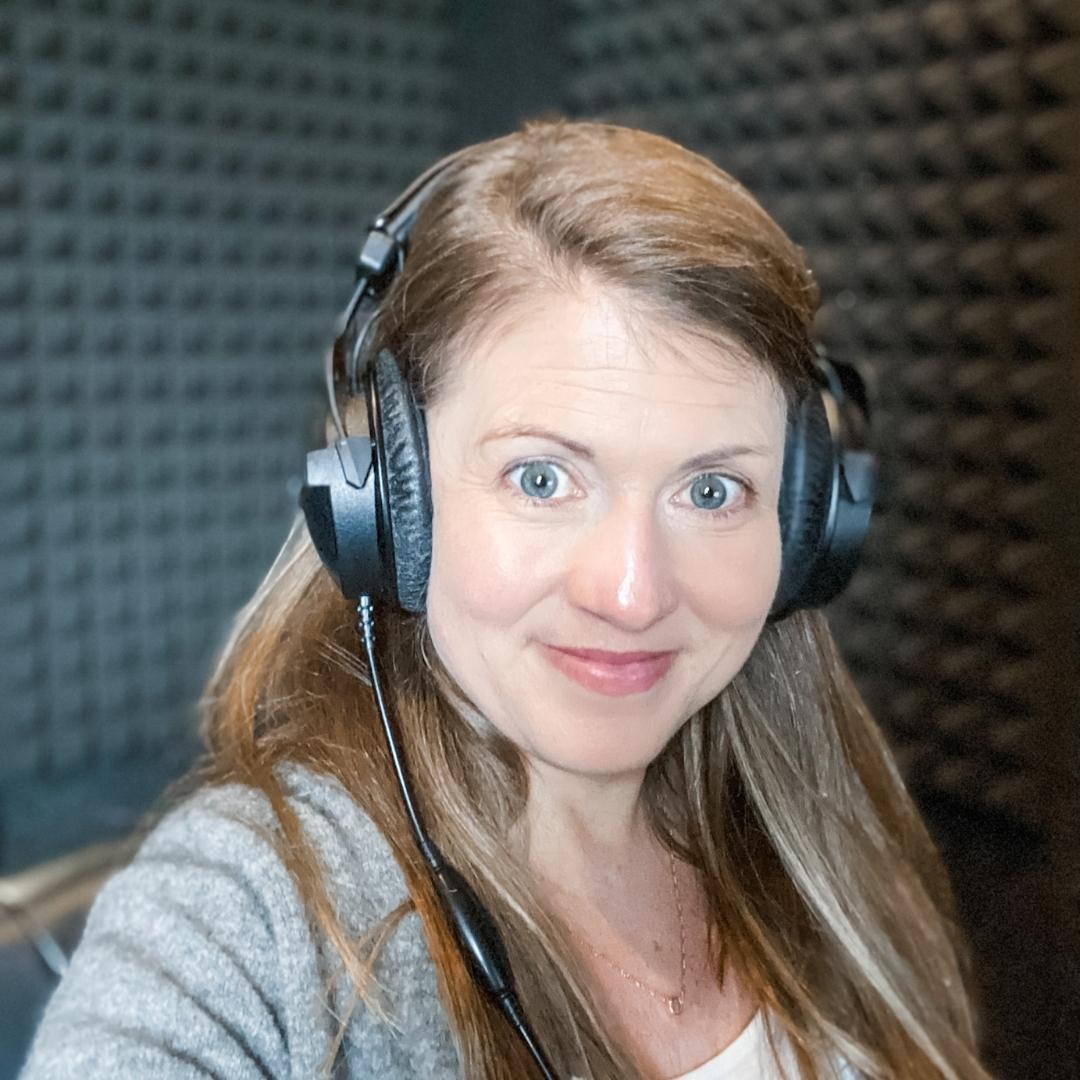 Amy Julia takes a selfie in a padded sound room. She is wearing large headphones.