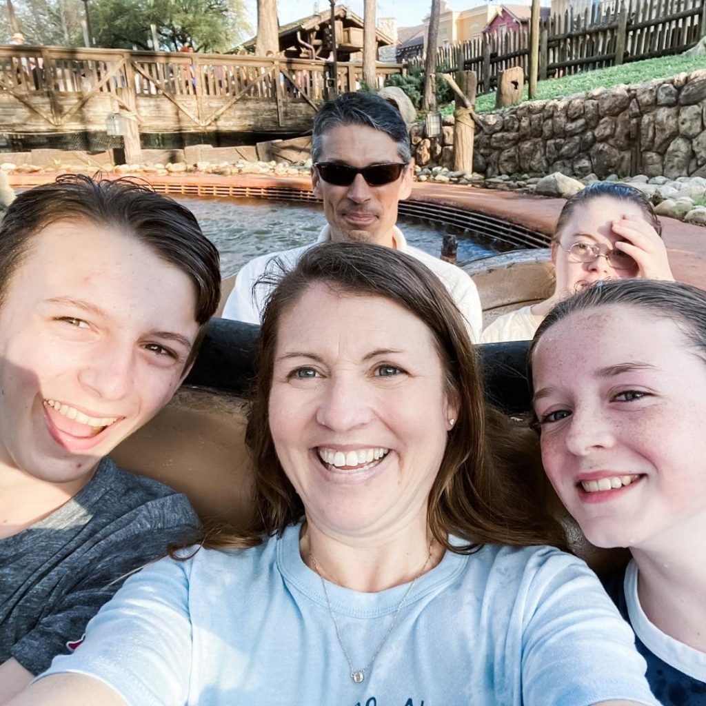Amy Julia and family smile at the camera on a ride at Disney