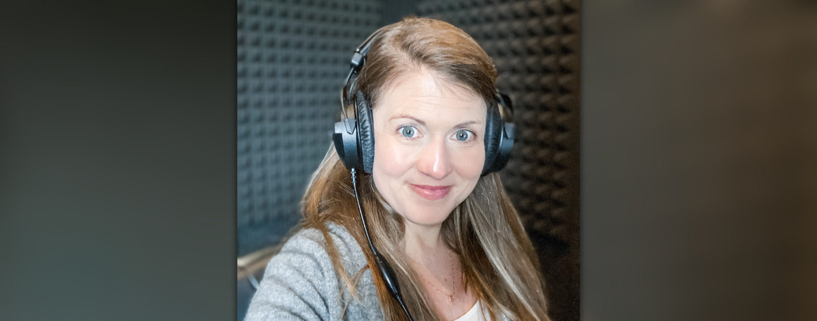 Amy Julia takes a selfie in a padded sound room. She is wearing large headphones