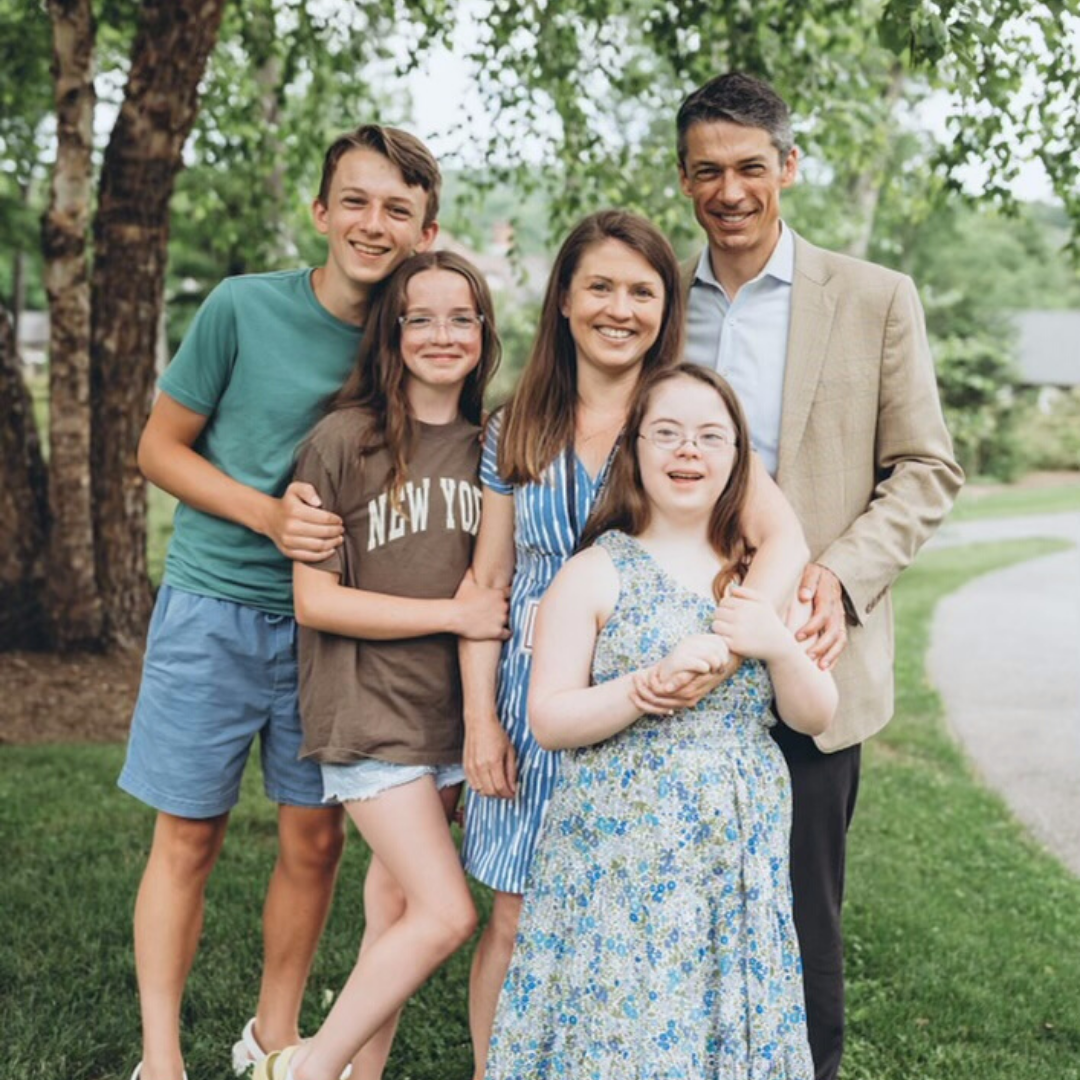 Amy Julia and family stand close together for a family picture outside