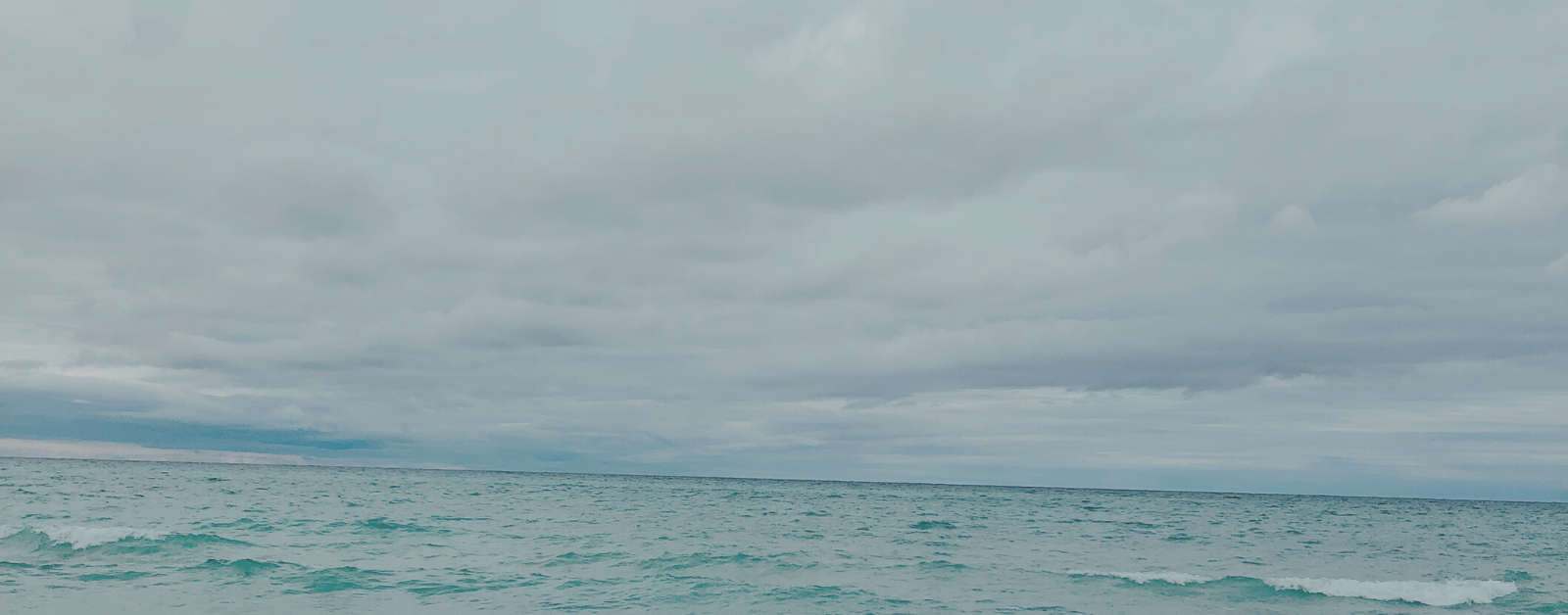 a blue lake meets a stormy horizon