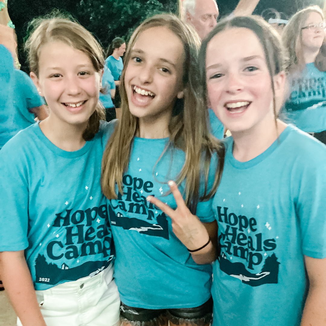 Marilee and friends smiling at the camera. They are all wearing blue Hope Heals Camp shirts