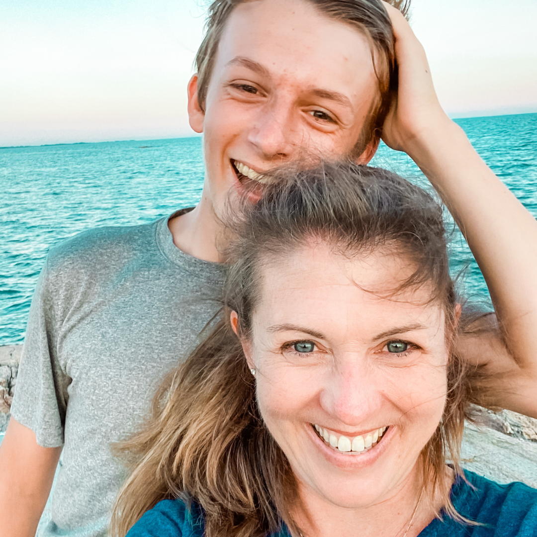 William and Amy Julia stand together in front of the ocean and smile widely