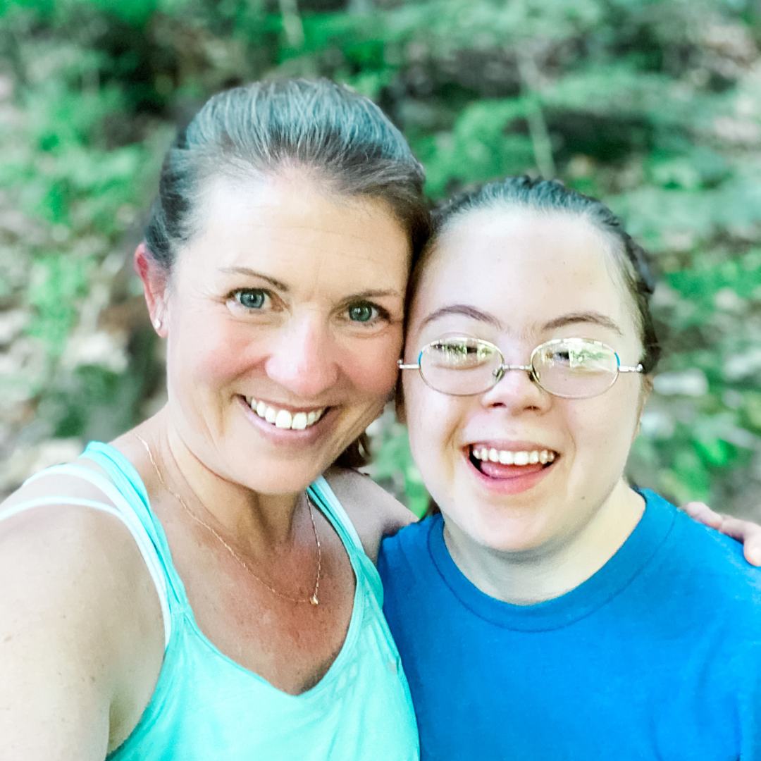 Amy Julia and Penny take a selfie in the forest. They smile widely at the camera and lean their heads against each other