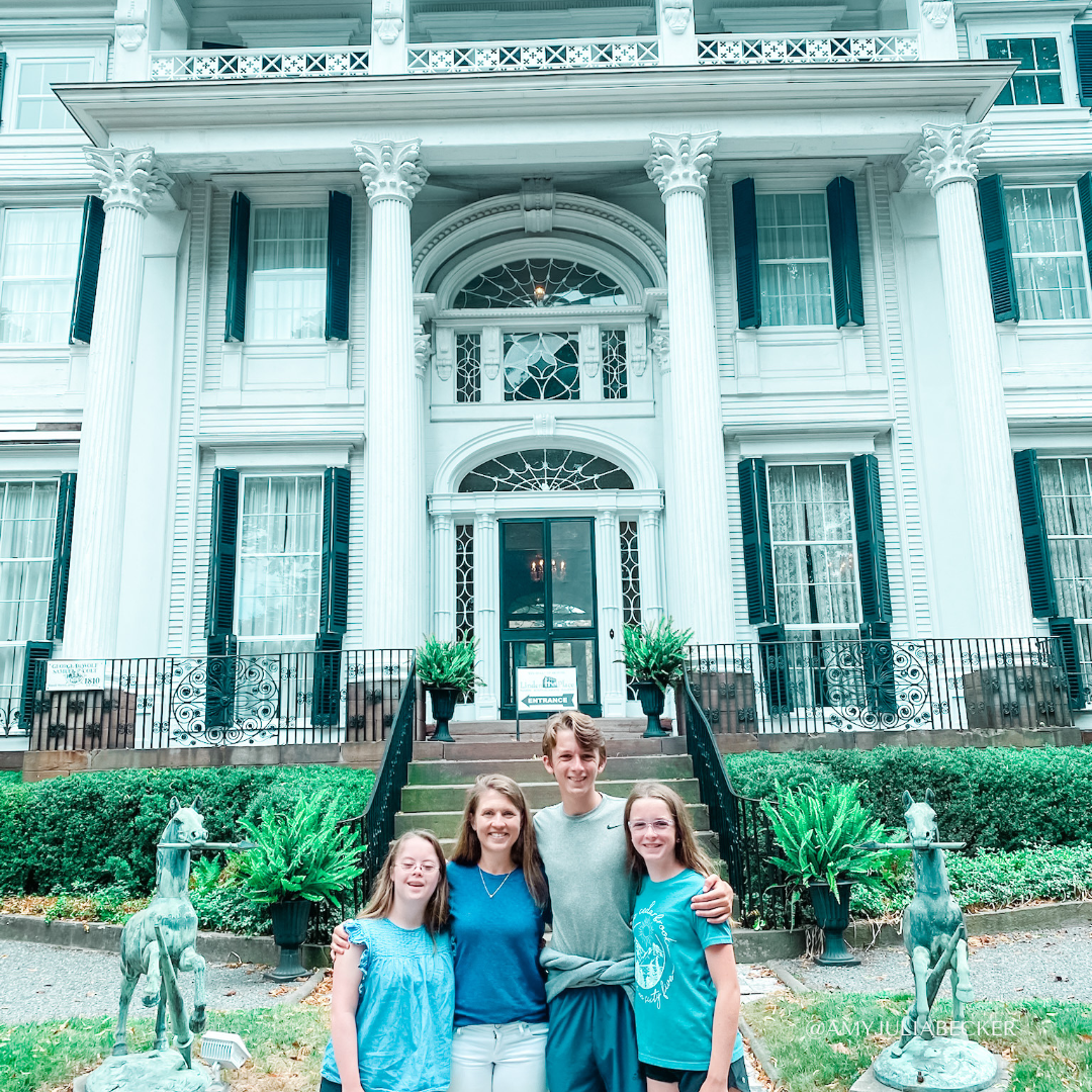Penny, Amy Julia, William, and Marilee stand in front of a tall white mansion with pillars that was turning into a museum