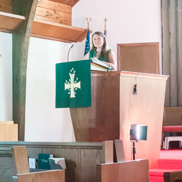 Amy Julia stands at a pulpit and preaches.