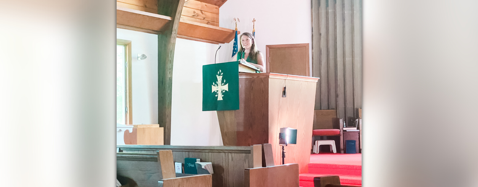 Amy Julia stands at a pulpit and preaches.
