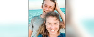 William and Amy Julia stand together in front of the ocean and smile widely