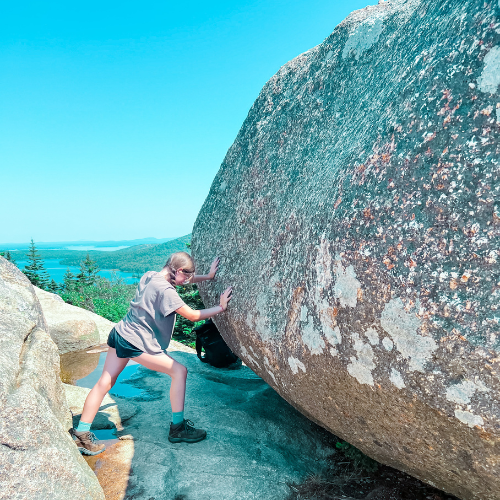 Marilee pushes against a huge rock