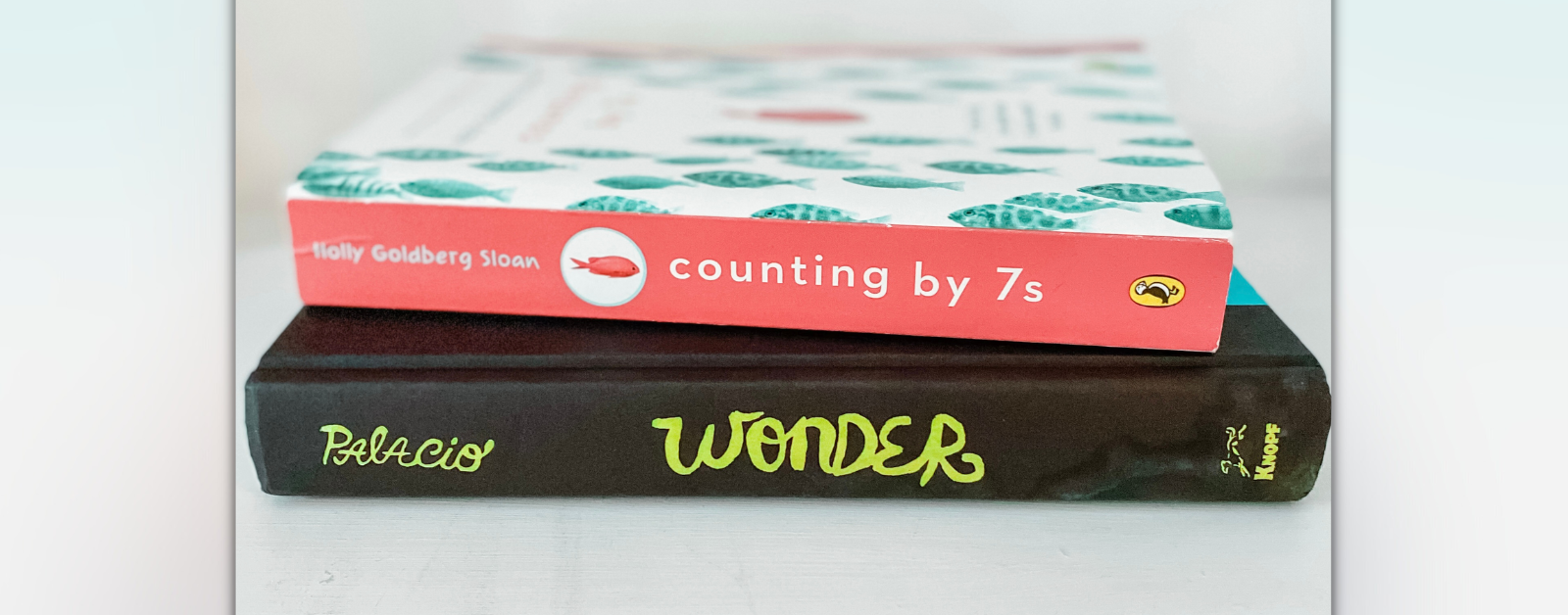 the book Counting by 7s stacked on top of the book Wonder