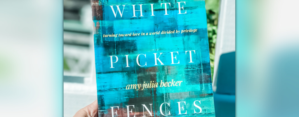 hand holding a copy of White Picket Fences