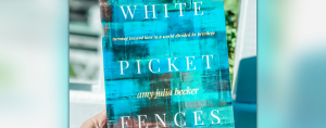 hand holding a copy of White Picket Fences