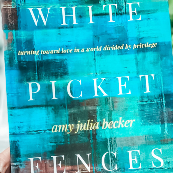 hand holding a copy of White Picket Fences