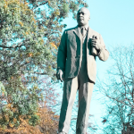 statue in a park of Martin Luther King Jr standing holding a Bible