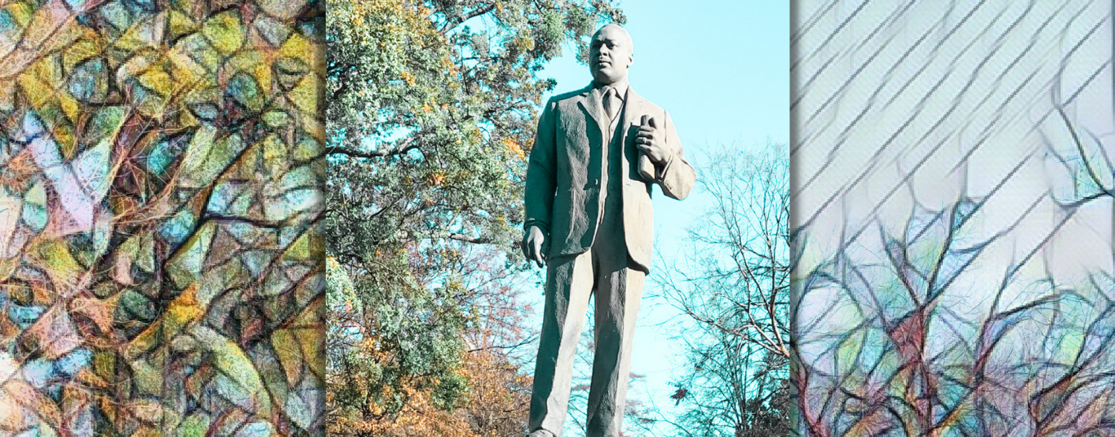 statue in a park of Martin Luther King Jr standing holding a Bible