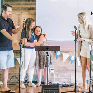 photo of Jay Wolf, Amy Julia, Penny, and Katherine Wolf standing at the front of a chapel