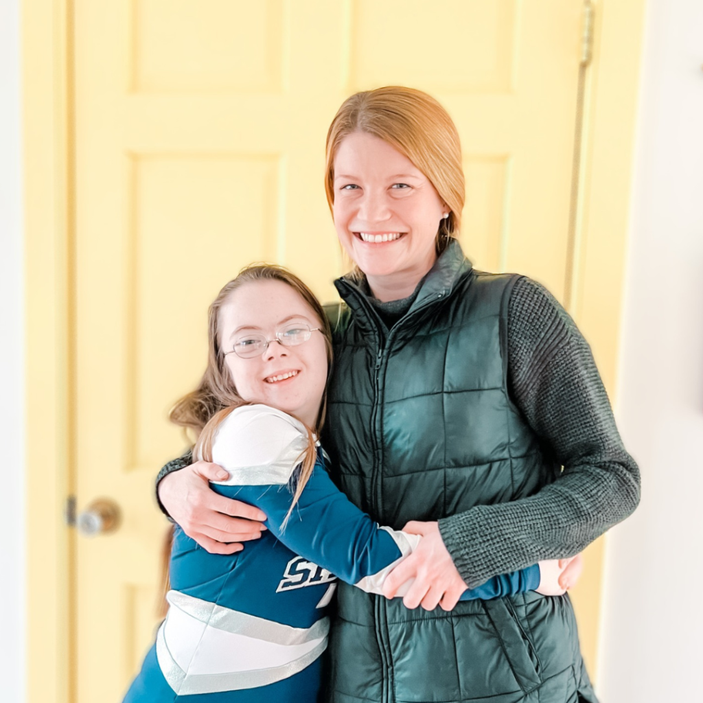 photo of Penny and her former babysitter Linnea giving each other a side hug in front of a yellow door