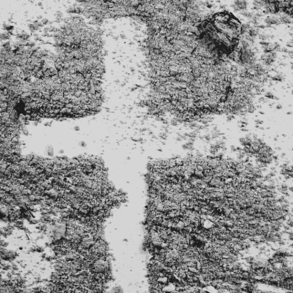 photo of a cross drawn in a pile of ash