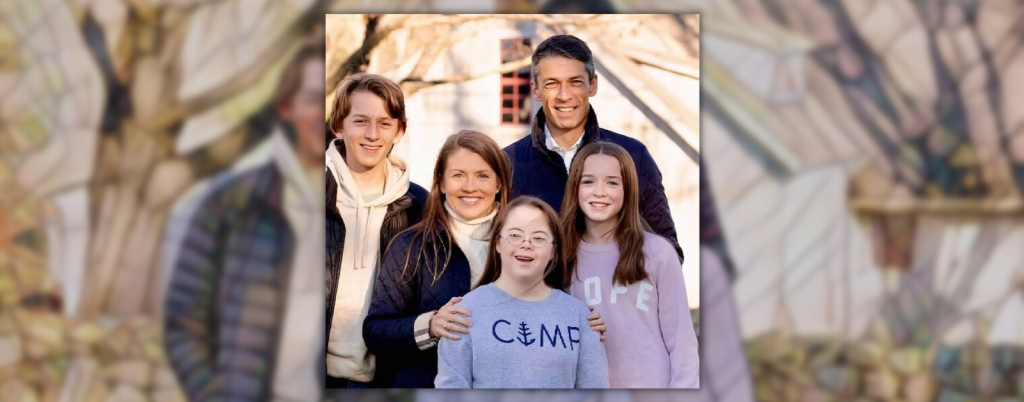 mosaic background behind an outdoor photo of Amy Julia's family. They are wearing coats and sweatshirts