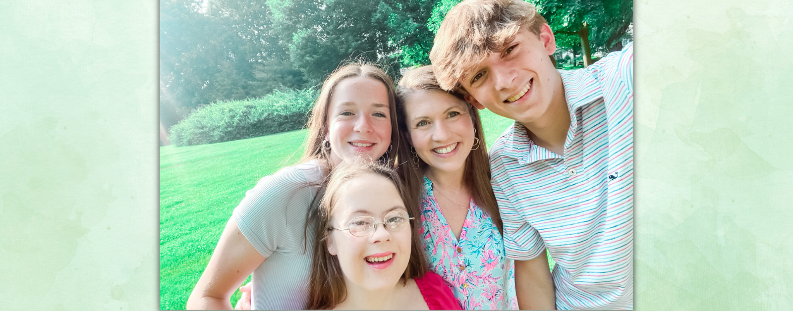 green background with photo of Penny, Marilee, Amy Julia, and William crowding together for a selfie outside