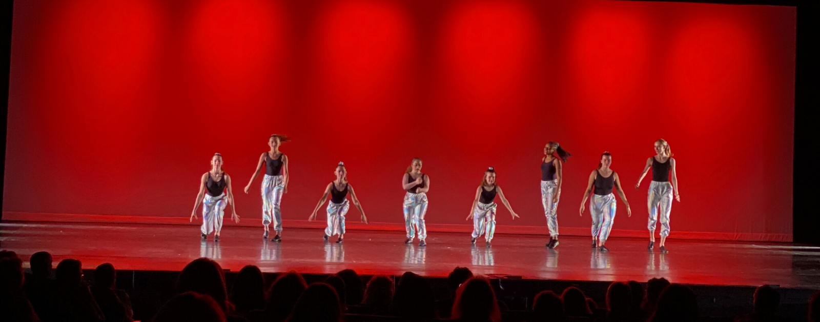 Penny in the center with her dance team performing on stage
