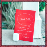 photo of the book Small Talk leaning against a white post with airpods next to it