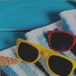 photo background of sunglasses and towel on blue planks