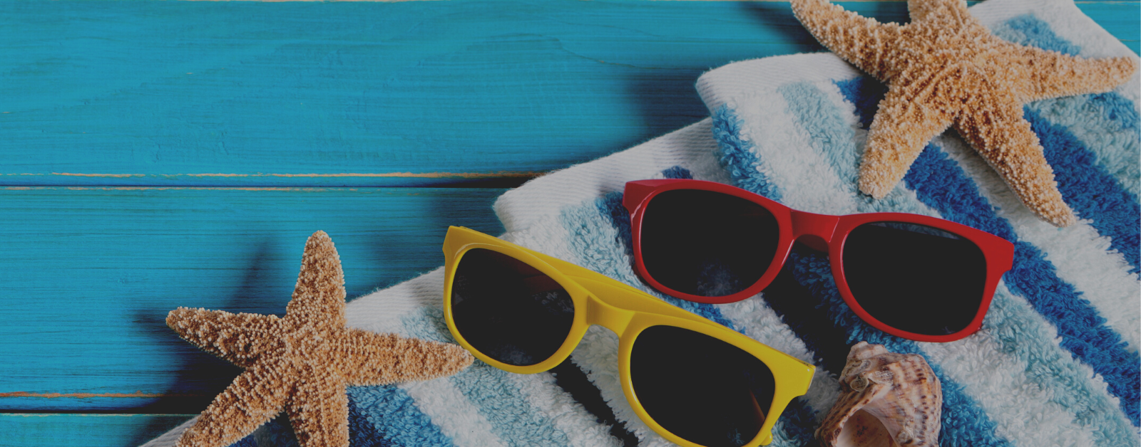 photo background of sunglasses and towel on blue planks