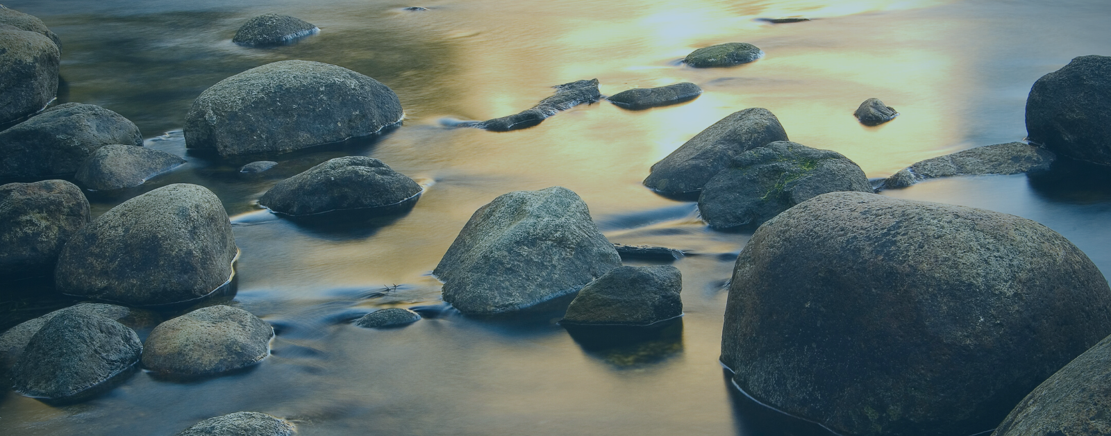 rocks in water with sun reflecting