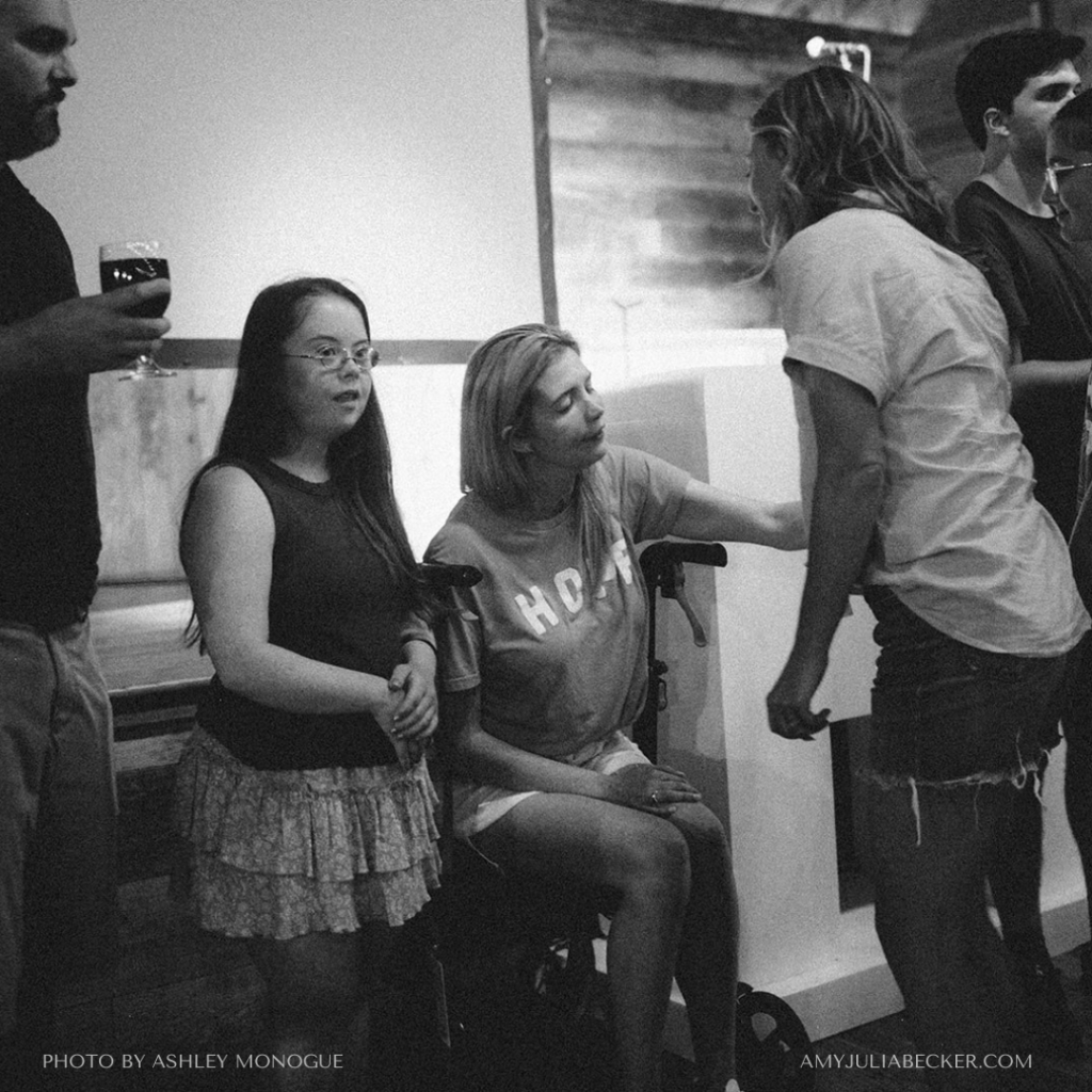 black and white photo of Penny standing at the front of a room with the Wolf family as communion is served