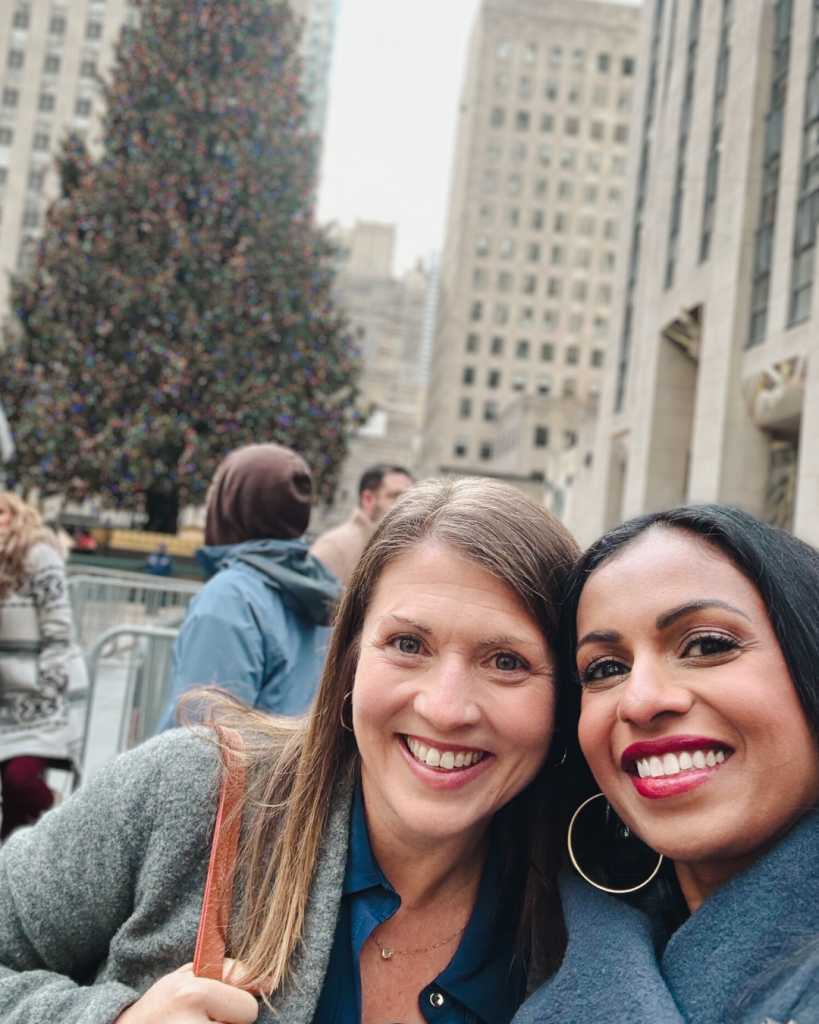 Amy Julia and Niro take a selfie in front of the Christmas tree at Rockefeller plaza
