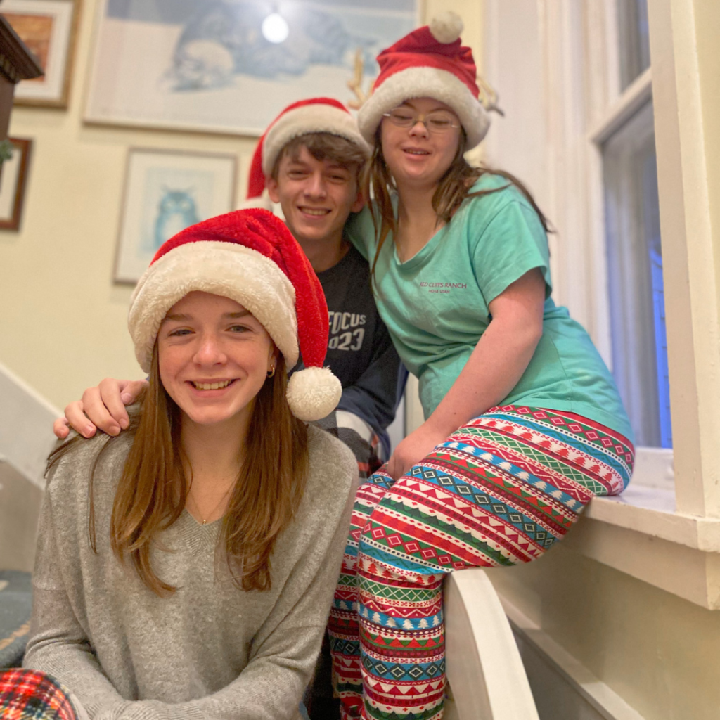 3 teens wearing santa hats