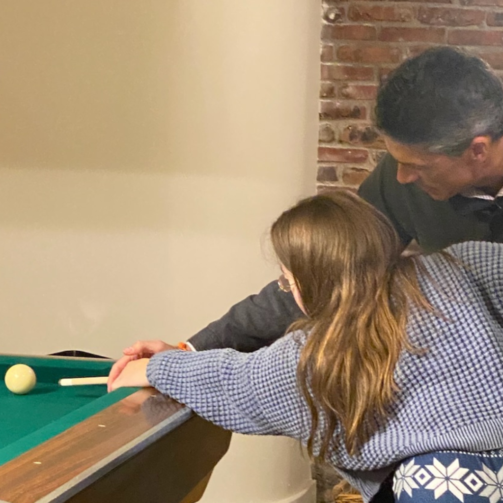 Peter teaching Penny to play pool