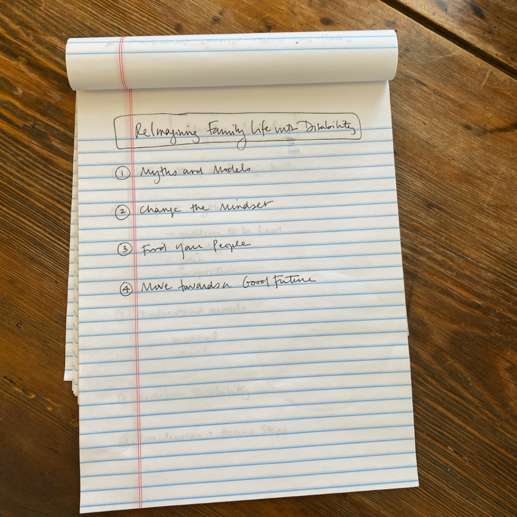 A legal pad on a wooden table with the title “Reimagining Family Life with Disability” written at the top and 4 points written underneath: “1. Myths and Models, 2. Change the Mindset, 3. Find Your People, 4. Move Toward a Good Future”