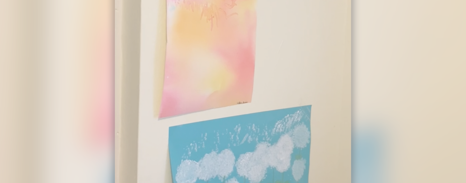 faded photo of children's brightly colored pictures on the wall