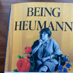 the book Being Heumann is on a wooden table