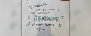 banner paper with text written on it that says: because she believes in the inherent belovedness of every human being