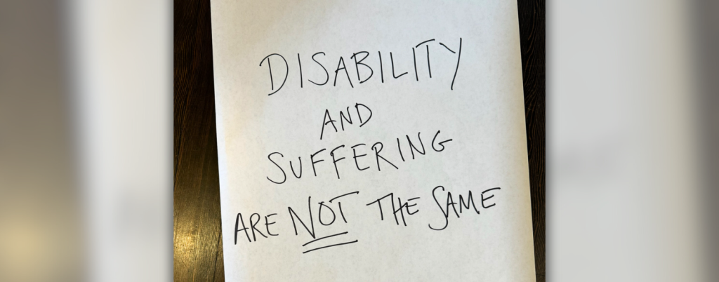 a large piece of white paper is on a wooden floor with the following written in large, all caps letters: “Disability and suffering are not the same."