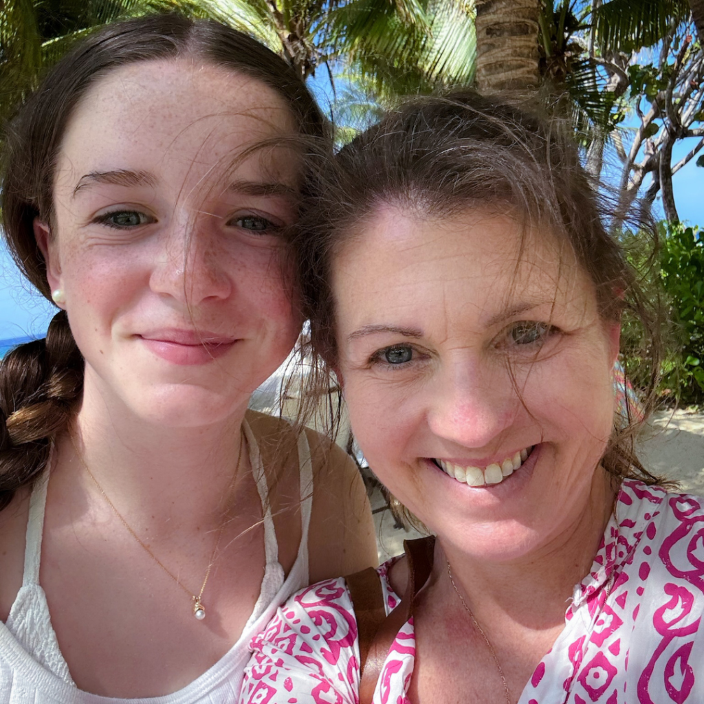 Marilee and Amy Julia take a selfie on the beach in front of a palm tree