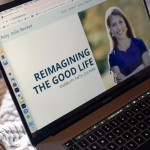 photo of a laptop on on top of a blanket. The home page of Amy Julia's website is on the screen, which has the logo "Reimagining the Good Life. Faith. Disability. Culture." on the left and a photo of Amy Julia standing outside on the right.