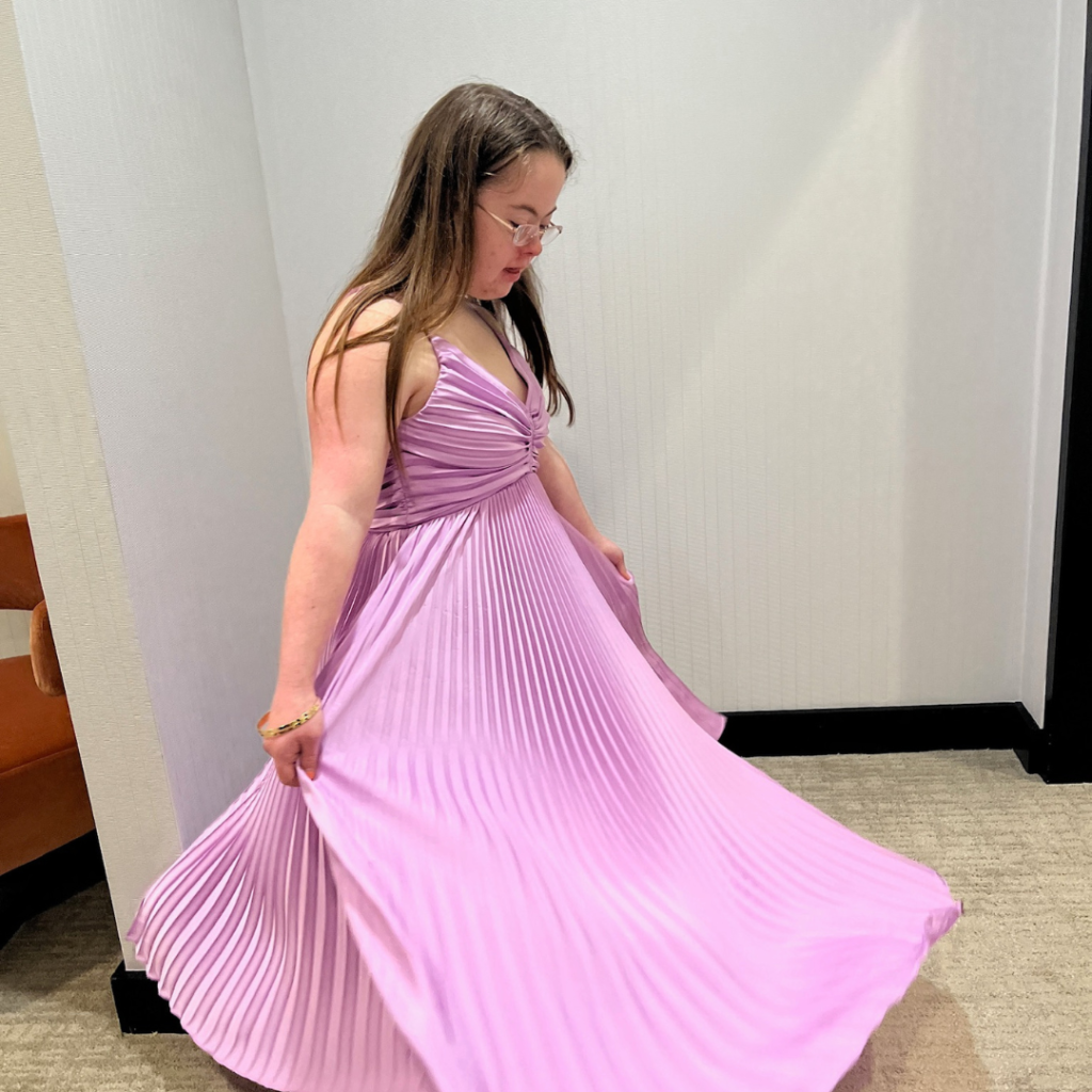 Penny twirls a pink prom dress in the changing room